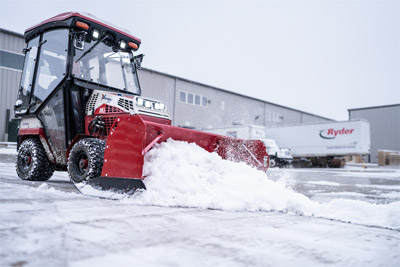 Ventrac Box Blade with Cab - Ventrac Box Snow Plow pushing snow off pavement.