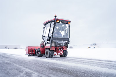 Ventrac Box Blade - Rear view of Ventrac equipped with a Cab and Box blade pushing snow.