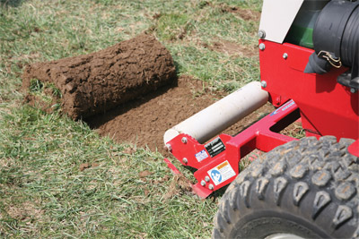Closeup of Sod Cutter Roller in use - The front roller helps lift up cut sod and consistently rolls it up as you move along.