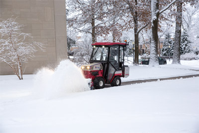 Ventrac 4500 Clearing Snow - Operators can stay warm and dry while battling winter thanks to an enclosed heated cab, ideal for campus grounds management.