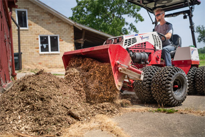 Ventrac Debris Removal - Wood Chips being dumped in a pile with the Ventrac Power bucket.