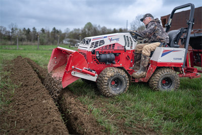 Ventrac Power Bucket - The Ventrac Power Rake efficiently places stone into drain lines, showcasing its versatility and precision. Ideal for landscaping and excavation, this hydraulically controlled attachment allows for smooth operation from the driver’s seat, making material transport and placement effortless.