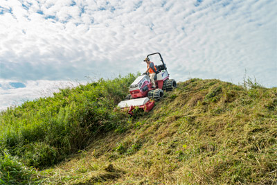 Ventrac Tough Cut - Best hillside mowers shown brush mowing steep slopes.