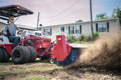 Ventrac Broom - Ventrac 4520 pushing woodchips off the lawn back into the stump hole.