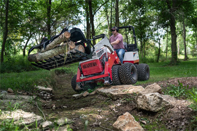 KM100 Rock Bucket with Grapple - The Ventrac Rock Bucket conquering varied terrain – seamlessly carrying logs over rocky landscapes, the agile tractor frame ensures effortless maneuvering, making property maintenance a breeze across diverse terrains.