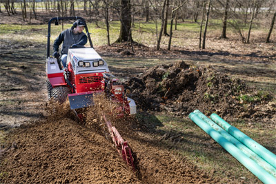Ventrac Trencher - Precision in action – Ventrac Trencher effortlessly carves a neat line for downspouts, showcasing its accuracy and efficiency in landscape drainage solutions.