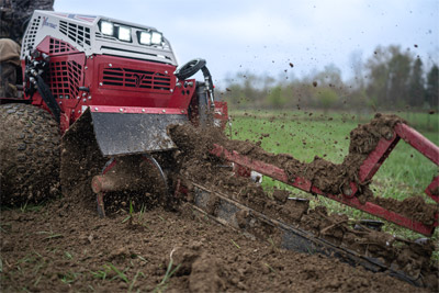 Ventrac Trencher - The Ventrac KY400 Trencher cuts through turf with precision, showcasing its 5½ inch wide cut and ability to reach depths of up to 40 inches. With carbide-tipped cutting chains and dual Push-N-Pull cylinders, it delivers excellent performance in various soil conditions while minimizing turf damage.