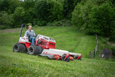 Ventrac Finish Mower - The Ventrac Finish Mower tackles the backside of a dam with ease, expertly cutting grass on a steep slope. Featuring quick height adjustments, rear rollers, and a robust steel deck, it delivers a beautifully striped finish even on challenging terrains.