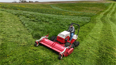 Ventrac Flail Mower - The Ventrac Flail Mower efficiently knocks down tall grass along a roadside, delivering a gorgeous finish despite its brush-mowing capabilities. It offers the perfect balance between the Tough Cut and Finish Mowers, handling rugged vegetation while ensuring a clean, professional look.