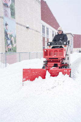 Ventrac V-Blade - The Ventrac SSV equipped with the V-Blade clearing snow from a walkway at a school. The powerful V-Blade efficiently pushes snow to the side, ensuring unobstructed paths for students and staff. Built for quick, effective snow removal, even in tight spaces.